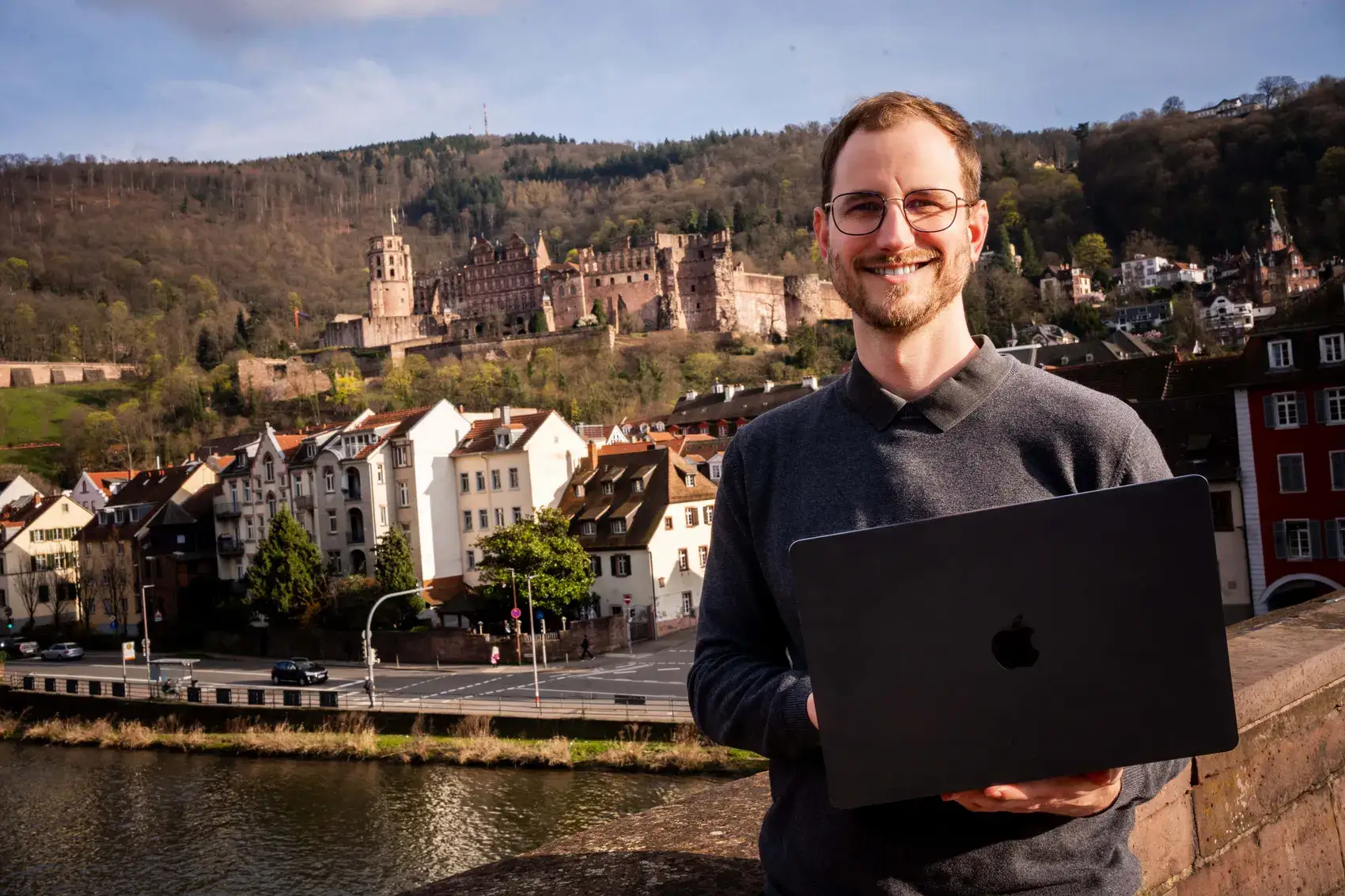 Joshua Stark mit Laptop vor dem Heidelberger Schloss